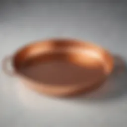 Close-up view of a beautifully crafted copper-bottomed skillet showcasing its shine and elegance.