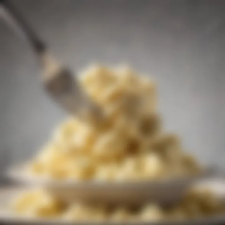 A close-up view of a fork lifting a fluffy scoop of mashed potatoes from the plate