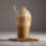 A close-up view of an iced brown sugar oatmilk shaken espresso with a frothy top and caramel drizzle.