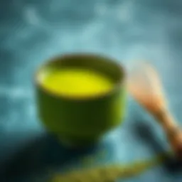 A vibrant bowl of matcha tea with a whisk beside it